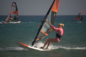 Surferka płynie na desce w ślizgu podczas szkolenia windsurfingowego na Prasonisi na Rodos w Grecji