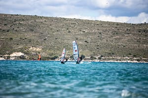 Na lekcji windsurfingu w Turcji instruktor uczy kursanta pływania w ślizgu
