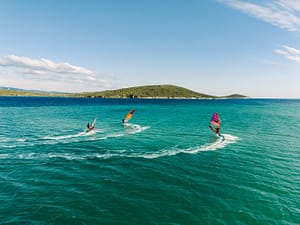Instruktor windsurfingu uczy kursantów rufy w ślizgu na lagunie w Tureckim Alacati