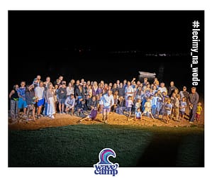 Grupa zadowolonych i wesołych uczestników windsurfingowego wyjazdu rodzinnego Wavecamp do Egiptu pozuje na plaży do zdjęcia