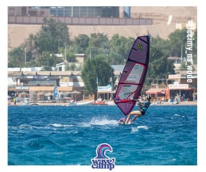 Kobieta w ślizgu płynie na desce windsurfingowej podczas szkolenia Wavecamp w Dahab na lagunie, Egipt