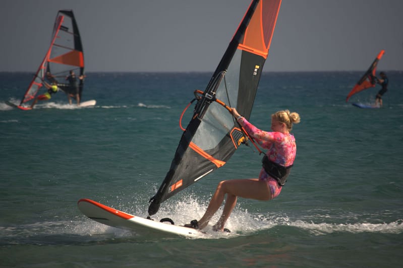 Surferka płynie na desce w ślizgu podczas szkolenia windsurfingowego na Prasonisi na Rodos w Grecji