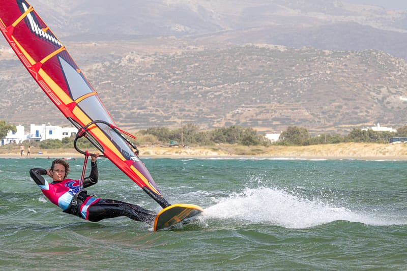 Instruktor windsurfingu Wavecamp płynie na desce w ślizgu na Naxos