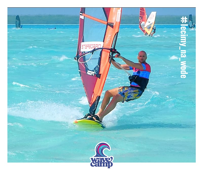 Windsurfer Maciek Kapuscinski płynie w ślizgu, przeżaglowany podczas mocnego wiatru na Bonaire na wyjeździe Wavecamp
